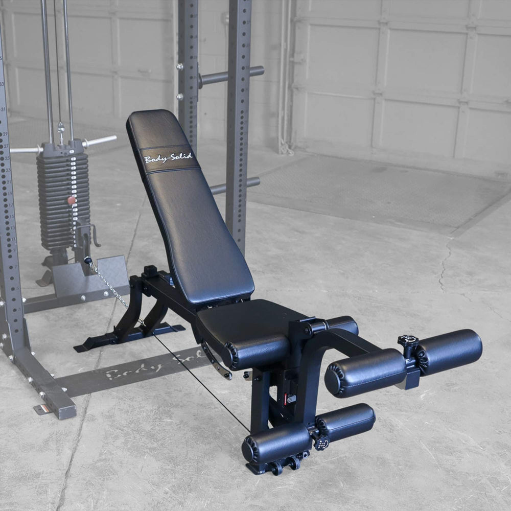 Body-Solid Leg Extension Curl Bench Attachment GLEG Adjustable weight bench with leg extension attachment positioned inside Body-Solid cable machine.