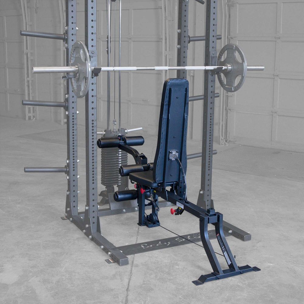 Body-Solid Leg Extension Curl Bench Attachment GLEG Rear view of Body-Solid adjustable bench with leg curl attachment inside power rack setup.