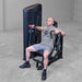 Body-Solid PCL2 Chest Press S2CPX Man performing chest press exercise on a Body-Solid Pro Club Line machine, arms extended and back supported by the seat.