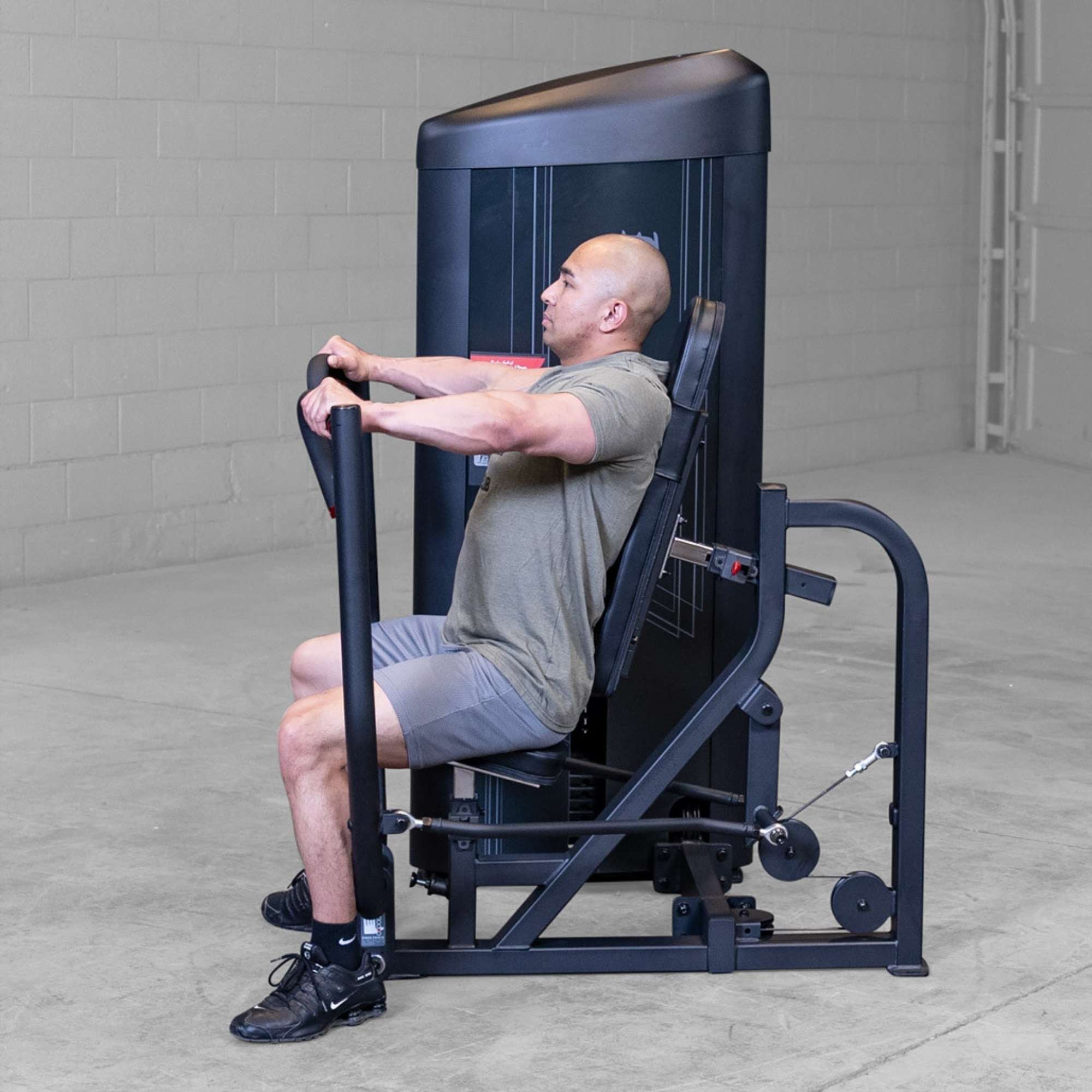 Body-Solid PCL2 Chest Press S2CPX Side view of a man pressing forward on a Body-Solid Pro Club Line machine, showing seated posture and full arm extension.
