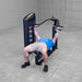 Body-Solid PCL2 Multi Press S2MPX Man lying on bench performing a wide-grip chest press with the machine arms extended