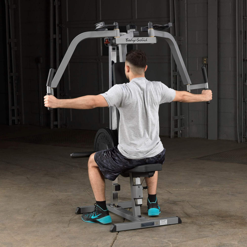 Body-Solid Plate Loaded Pec Deck GPM65B Man performing rear delt flys using the Body-Solid pec deck machine with wide arm extension