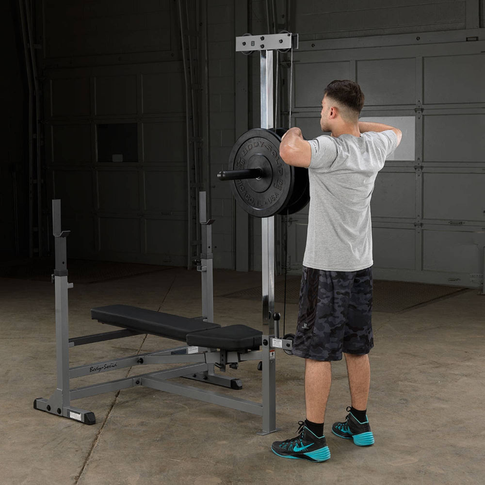 Body-Solid Powercenter Rack Bench Combo GDIB46LB Man performing upright row facing lat tower on Body-Solid gym setup