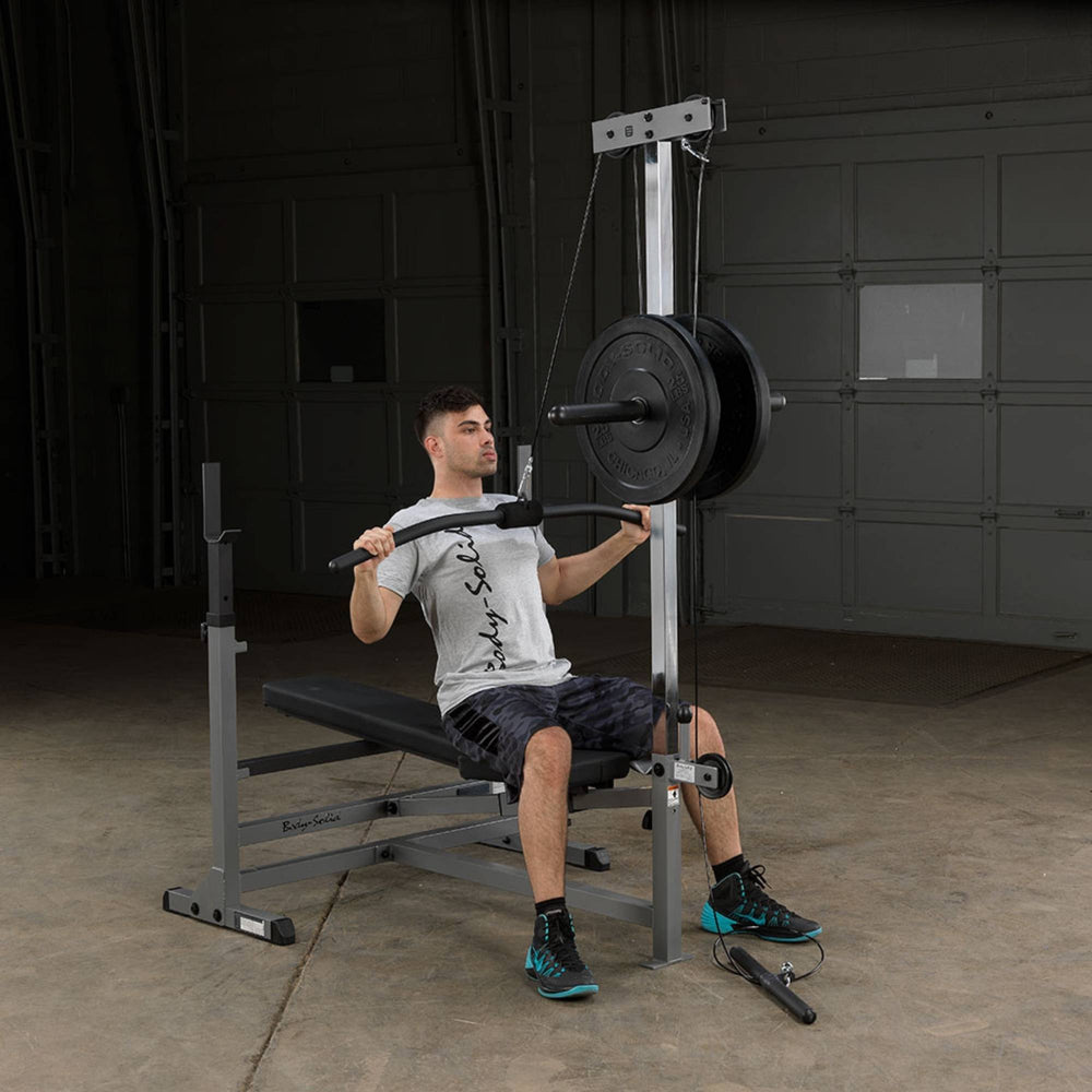 Body-Solid Powercenter Rack Bench Combo GDIB46LB Seated lat pulldown exercise with bar on Body-Solid home gym station