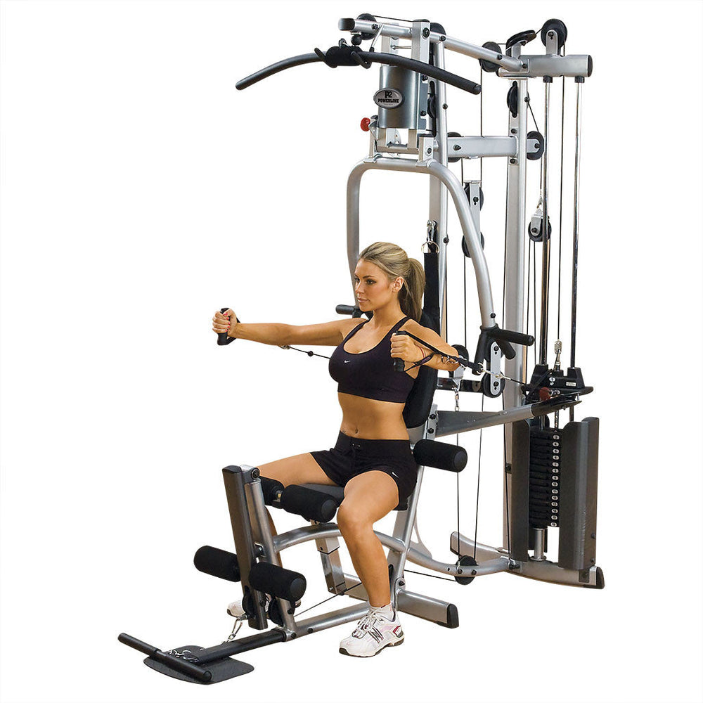 Woman exercising on a Body-Solid P2X home gym machine with a white background doing pec flys