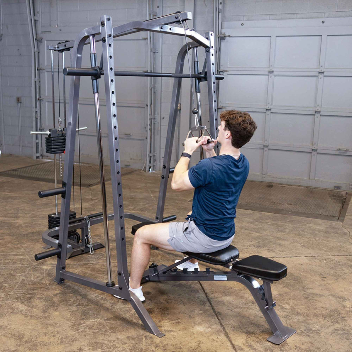 Body-Solid Powerline PSM200 Smith Machine Package PSM200P4 Man using Body-Solid Smith Machine with lat pulldown attachment