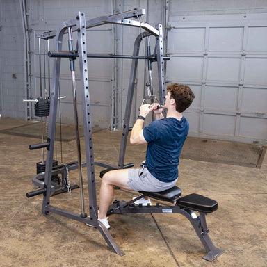 Body-Solid Powerline PSM200 Smith Machine Package PSM200P4 Man using Body-Solid Smith Machine with lat pulldown attachment