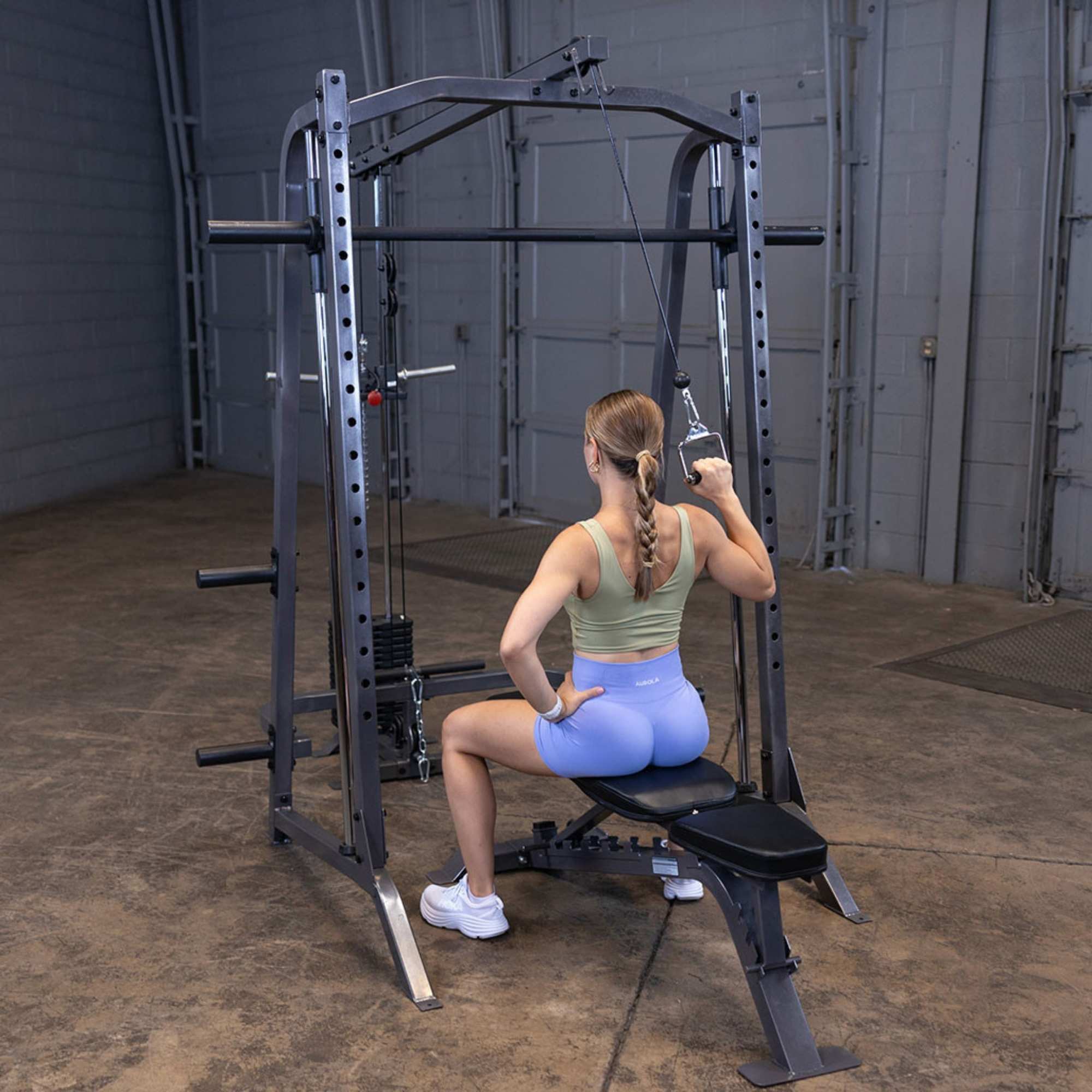 Body-Solid Powerline PSM200 Smith Machine Package PSM200P4 Woman doing single-arm lat pulldown on Body-Solid Smith Machine
