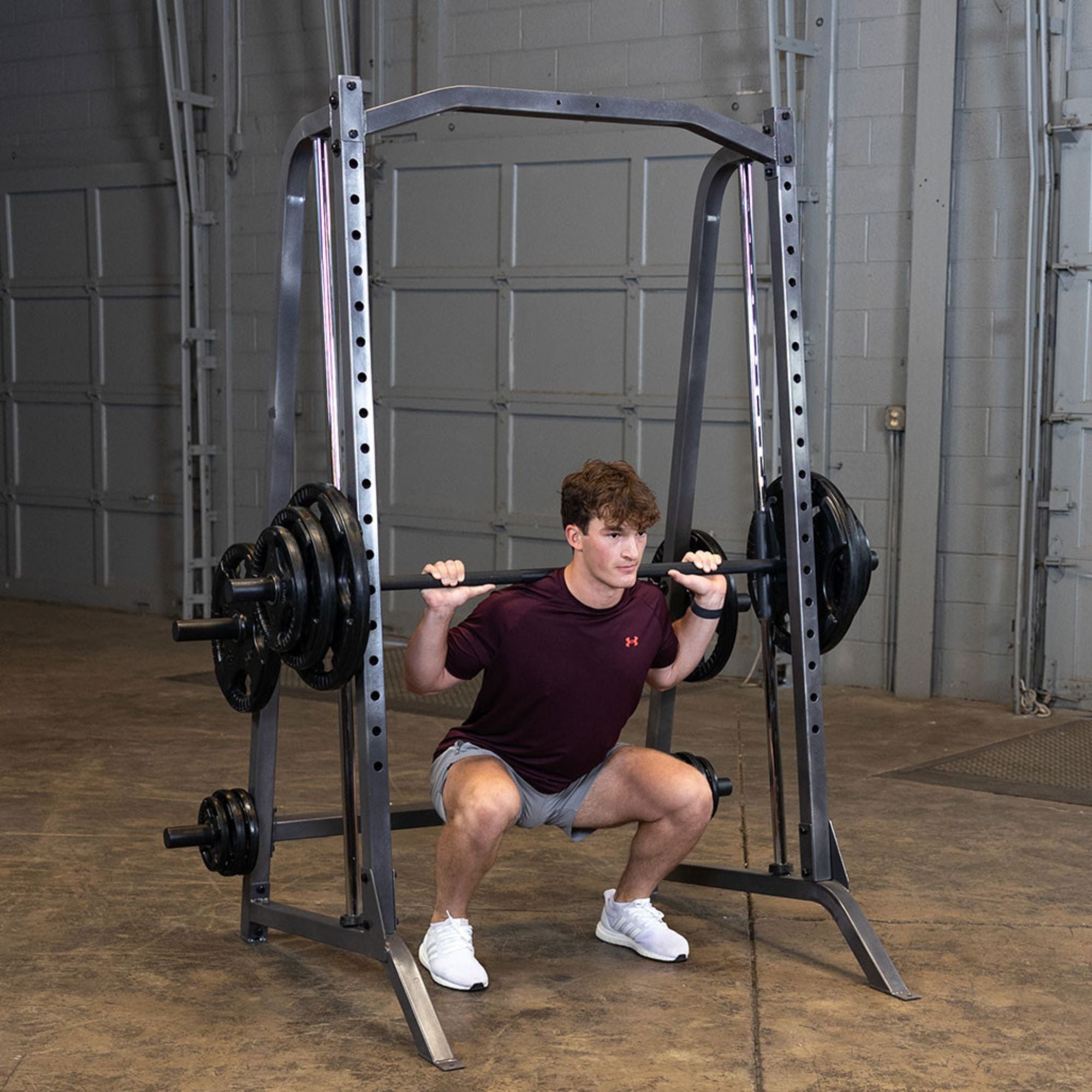 Body-Solid Powerline Smith Machine PSM200 Man executing barbell squats on Body-Solid Smith machine for leg training

