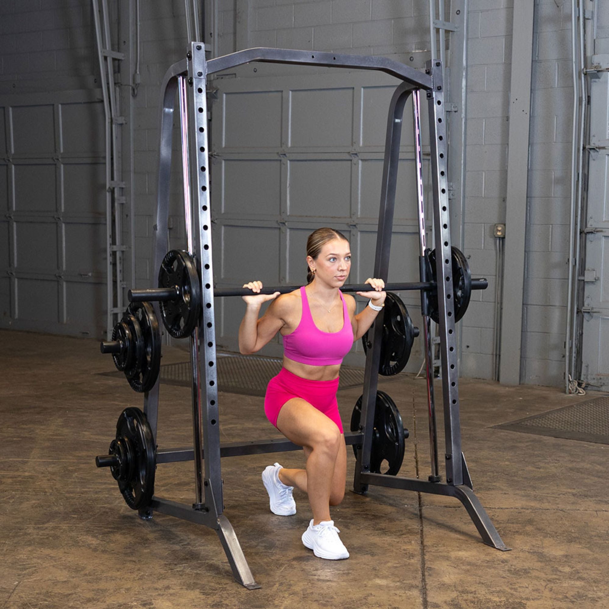 Body-Solid Powerline Smith Machine PSM200 Woman doing barbell lunges on Body-Solid Smith machine for lower body toning