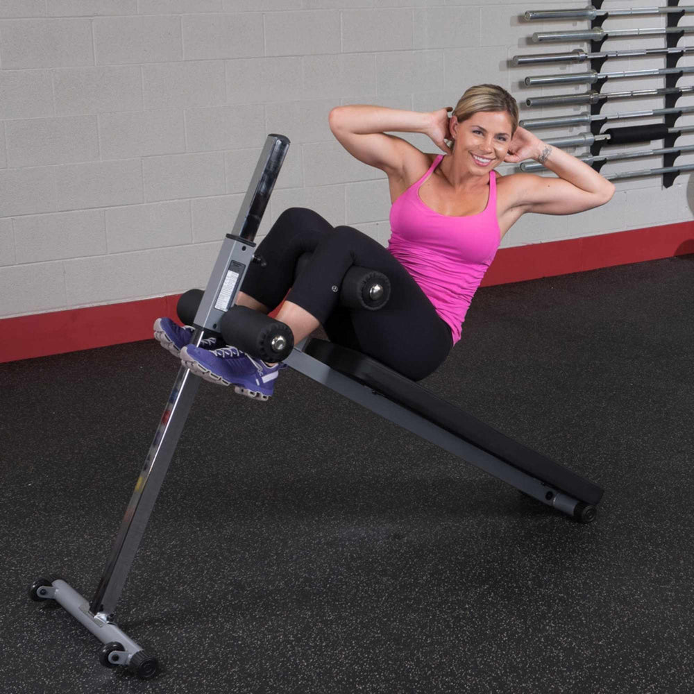 Body-Solid Pro-Style Adjustable Ab Board GAB60B Twisting sit-up on adjustable ab bench with woman smiling during exercise