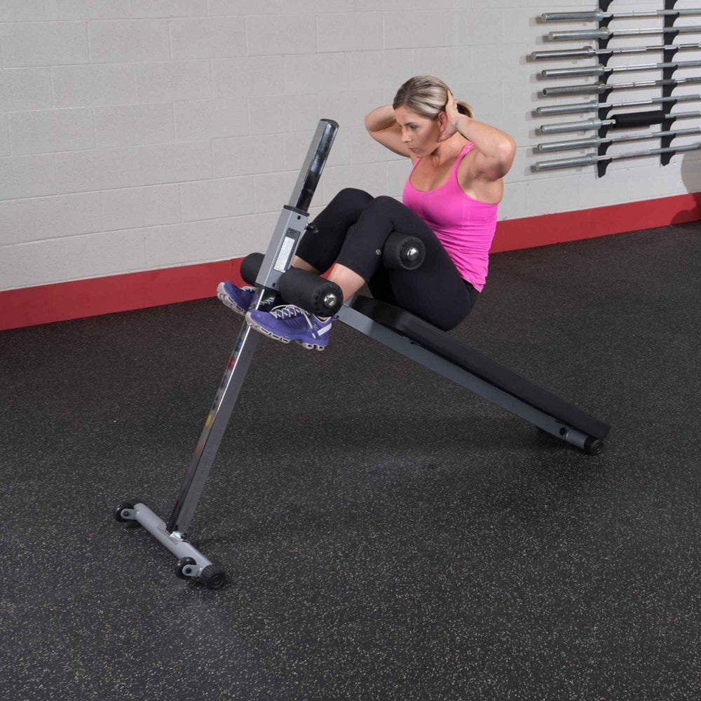 Body-Solid Pro-Style Adjustable Ab Board GAB60B Woman performing oblique sit-up on adjustable decline bench