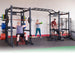 Body-Solid Pro ClubLine Double Power Racks with Rear Extensions and Monkey Bars with Safety Straps SPR1000SSDBBACK A group of four people exercising on a large, multi-station black fitness rig in a gym
