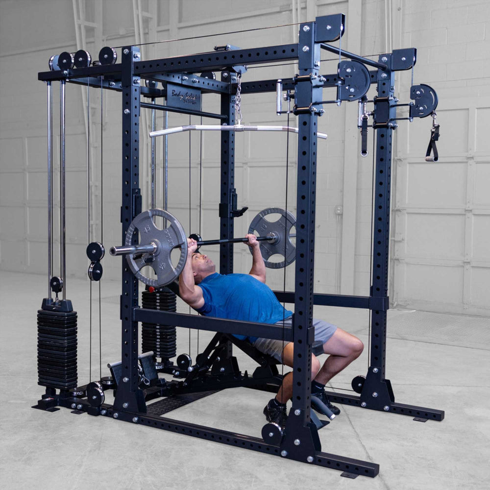 Body-Solid Pro ClubLine Functional Trainer Attachment SPRFTS Man performing incline bench press with barbell inside Body-Solid Pro ClubLine SPRFTS power rack functional trainer.
