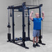 Body-Solid Pro ClubLine Functional Trainer Attachment SPRFTS Man performing seated low row exercise using cable attachment on Body-Solid SPRFTS power rack functional trainer.
