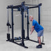 Body-Solid Pro ClubLine Functional Trainer Attachment SPRFTS Man performing standing triceps extension using high pulley and straight bar on Body-Solid SPRFTS functional trainer system.