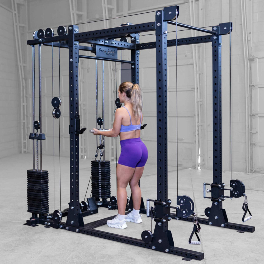 Body-Solid Pro ClubLine Functional Trainer Attachment SPRFTS Woman executing bent-over dual cable row using handles on Body-Solid Pro ClubLine SPRFTS power rack.
