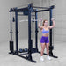 Body-Solid Pro ClubLine Functional Trainer Attachment SPRFTS Woman executing triceps pushdown using cable attachment on Body-Solid SPRFTS functional trainer power rack.
