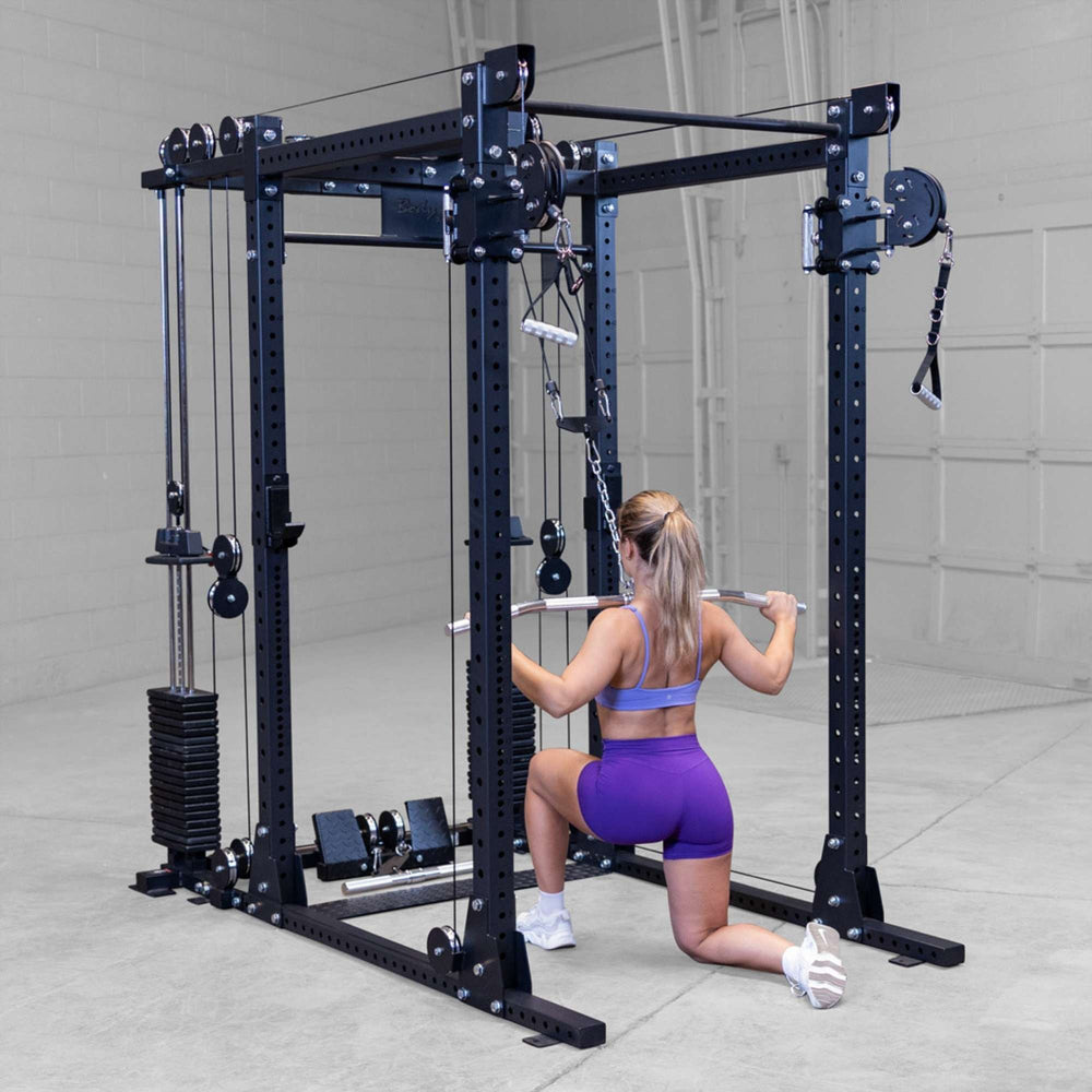 Body-Solid Pro ClubLine Functional Trainer Attachment SPRFTS Woman holding barbell at thighs after completing triceps pushdown on Body-Solid Pro ClubLine SPRFTS system.

