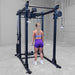 Body-Solid Pro ClubLine Functional Trainer Attachment SPRFTS Woman performing kneeling lat pulldown using wide grip bar on Body-Solid SPRFTS functional trainer.

