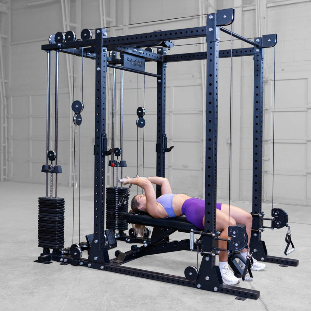 Body-Solid Pro ClubLine Functional Trainer Attachment SPRFTS Woman performing lying cable pullover on adjustable bench inside Body-Solid Pro ClubLine SPRFTS functional trainer.
