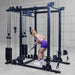 Body-Solid Pro ClubLine Functional Trainer Attachment SPRFTS Woman performing standing single-arm cable curl facing weight stacks on Body-Solid SPRFTS functional trainer.
