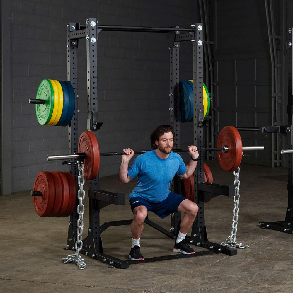 Body-Solid Pro ClubLine Half Rack with Rear Extension SPR500BACK Man performing squats with chains inside