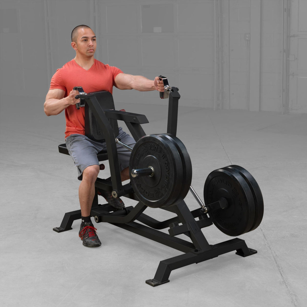 Body-Solid Pro ClubLine LVSR Leverage Seated Row LVSRB Man performing seated row exercise on Body-Solid LVSR machine with weight plates loaded, using independent lever arms for full back engagement.
