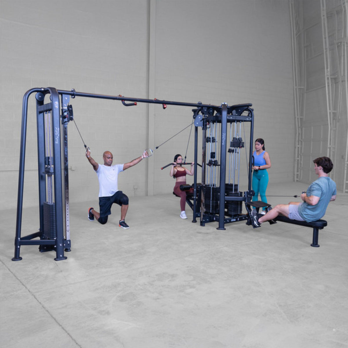 Body-Solid Pro ClubLine SJG Jungle Gym SJG500 Fitness group using commercial-grade cable crossover gym performing lunges, pulldowns, and seated row exercises.
