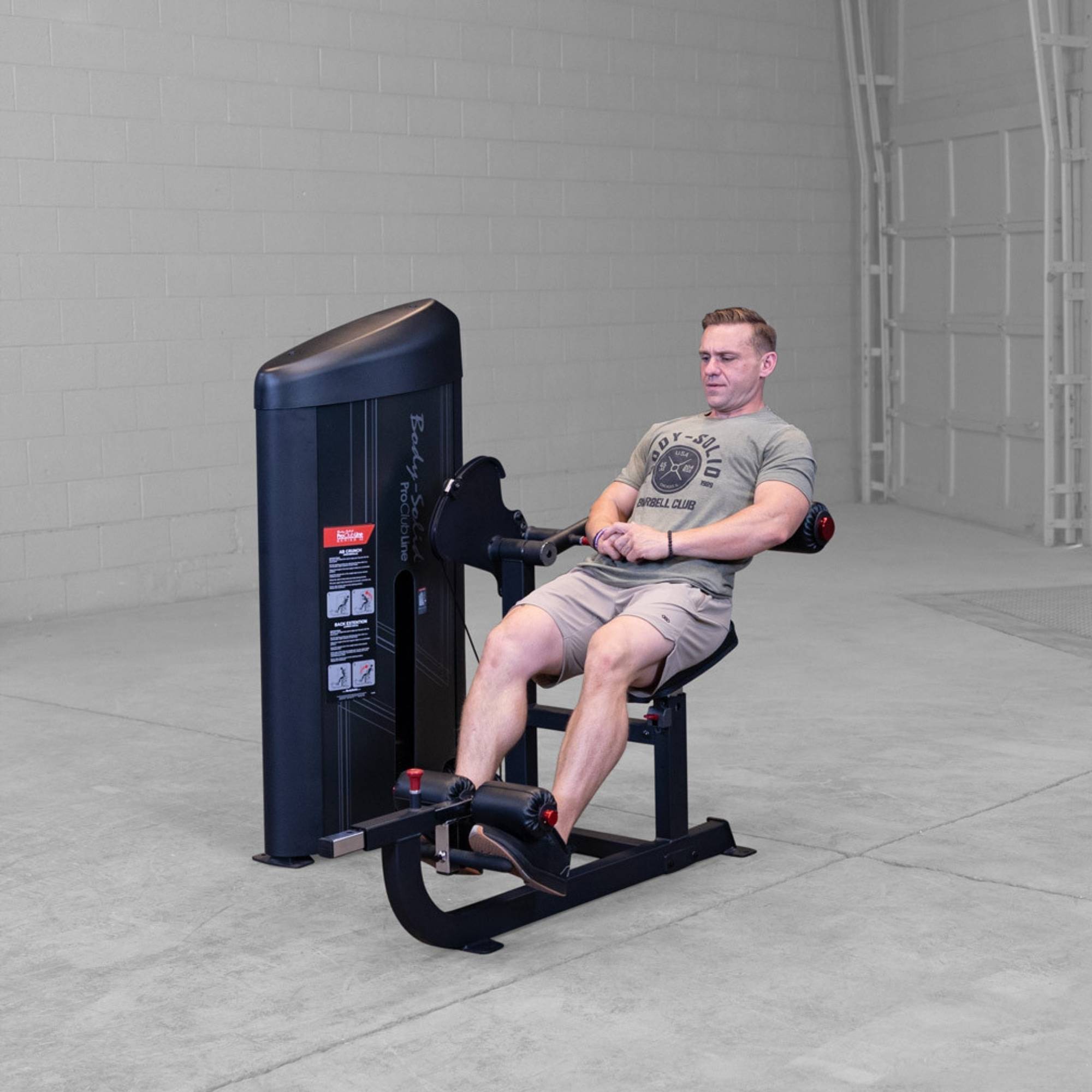 Body-Solid Pro ClubLine Series 2 Ab and Back S2ABBX Man leaning back for controlled back extension on Body-Solid ProClubLine ab crunch and extension combo machine.
