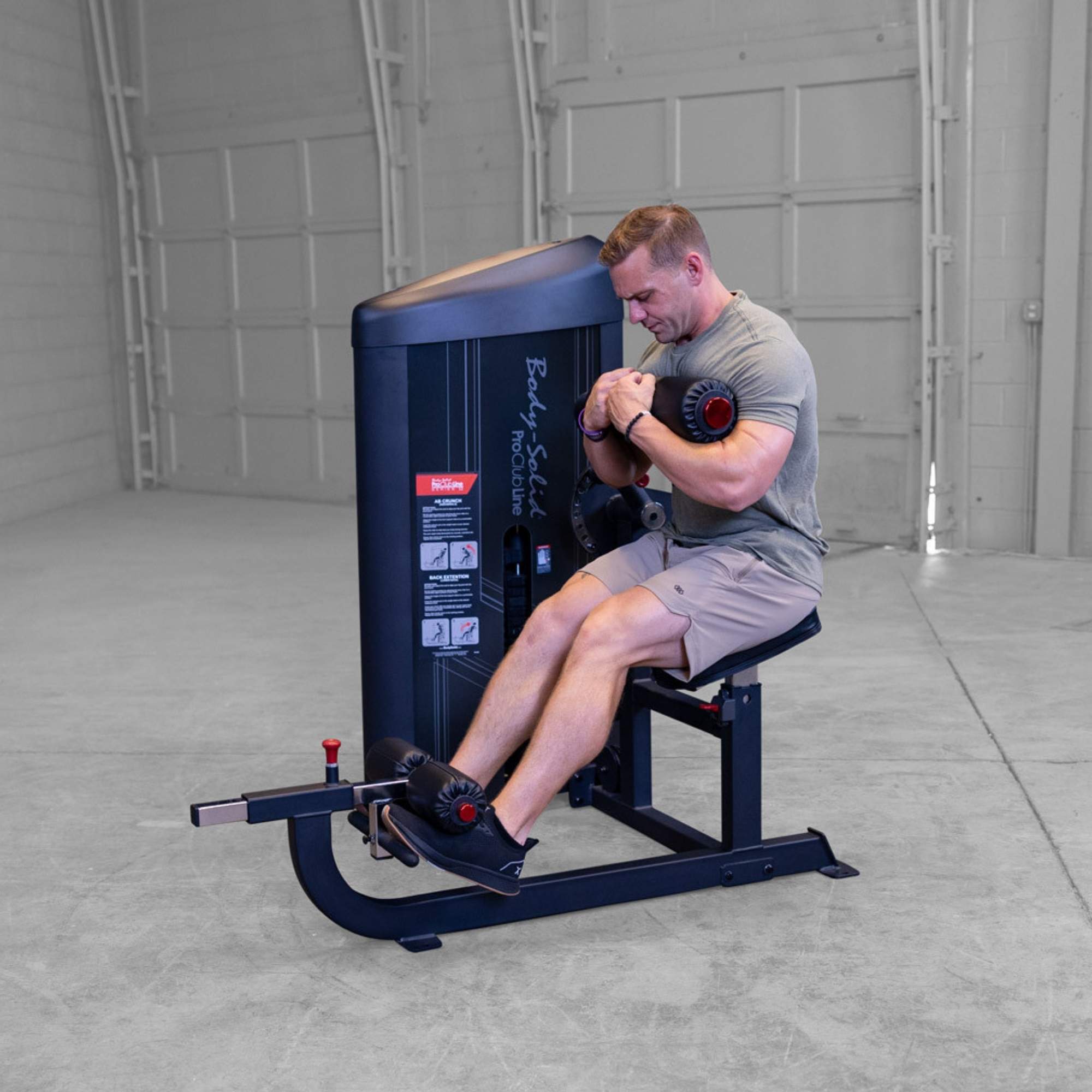 Body-Solid Pro ClubLine Series 2 Ab and Back S2ABBX Man performing upper-body crunch movement on Body-Solid ProClubLine dual-function ab and back workout machine.
