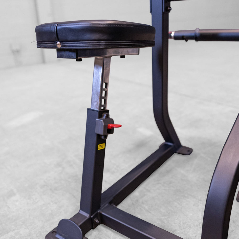 Body-Solid Pro ClubLine Series 2 Arm Curl S2ACX Adjustable padded seat with height adjustment lever on an arm curl machine in a gym