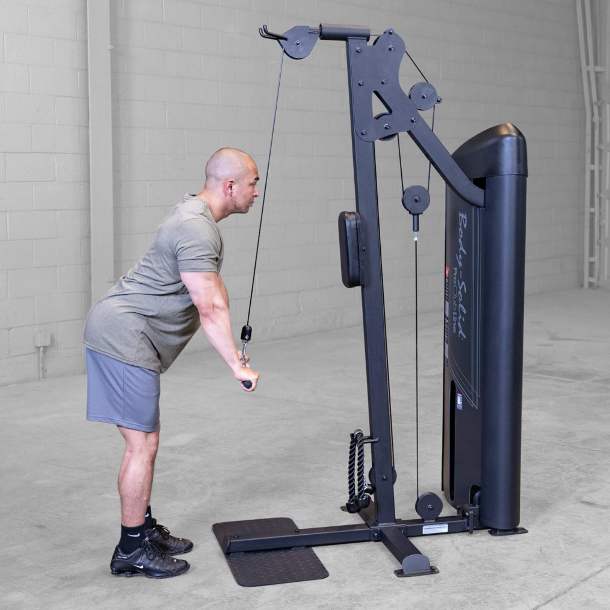 Body-Solid Pro ClubLine Series 2 Biceps Triceps S2BTPX Man bending forward with elbows locked while pushing a cable handle downward for triceps engagement.