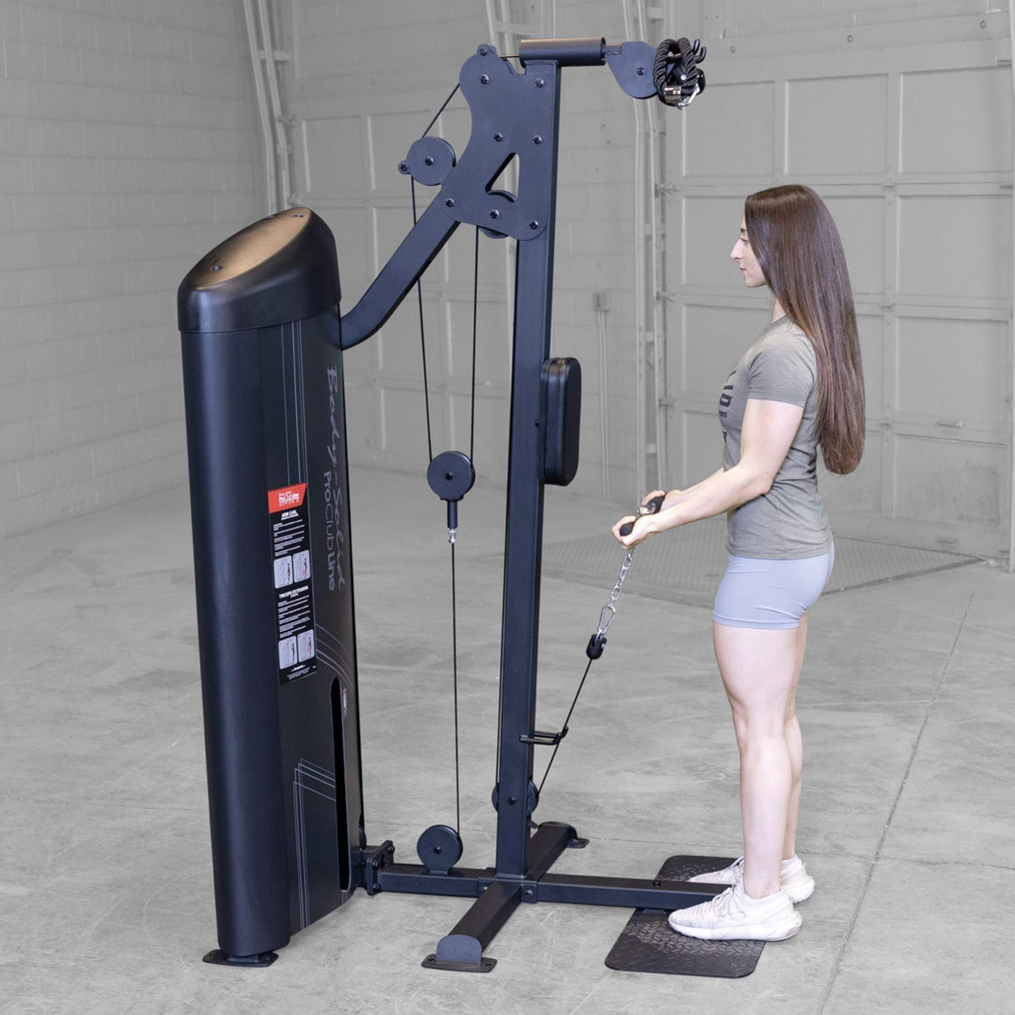 Body-Solid Pro ClubLine Series 2 Biceps Triceps S2BTPX Side view of woman holding a short bar attachment while performing cable curl exercise on a Body-Solid machine.