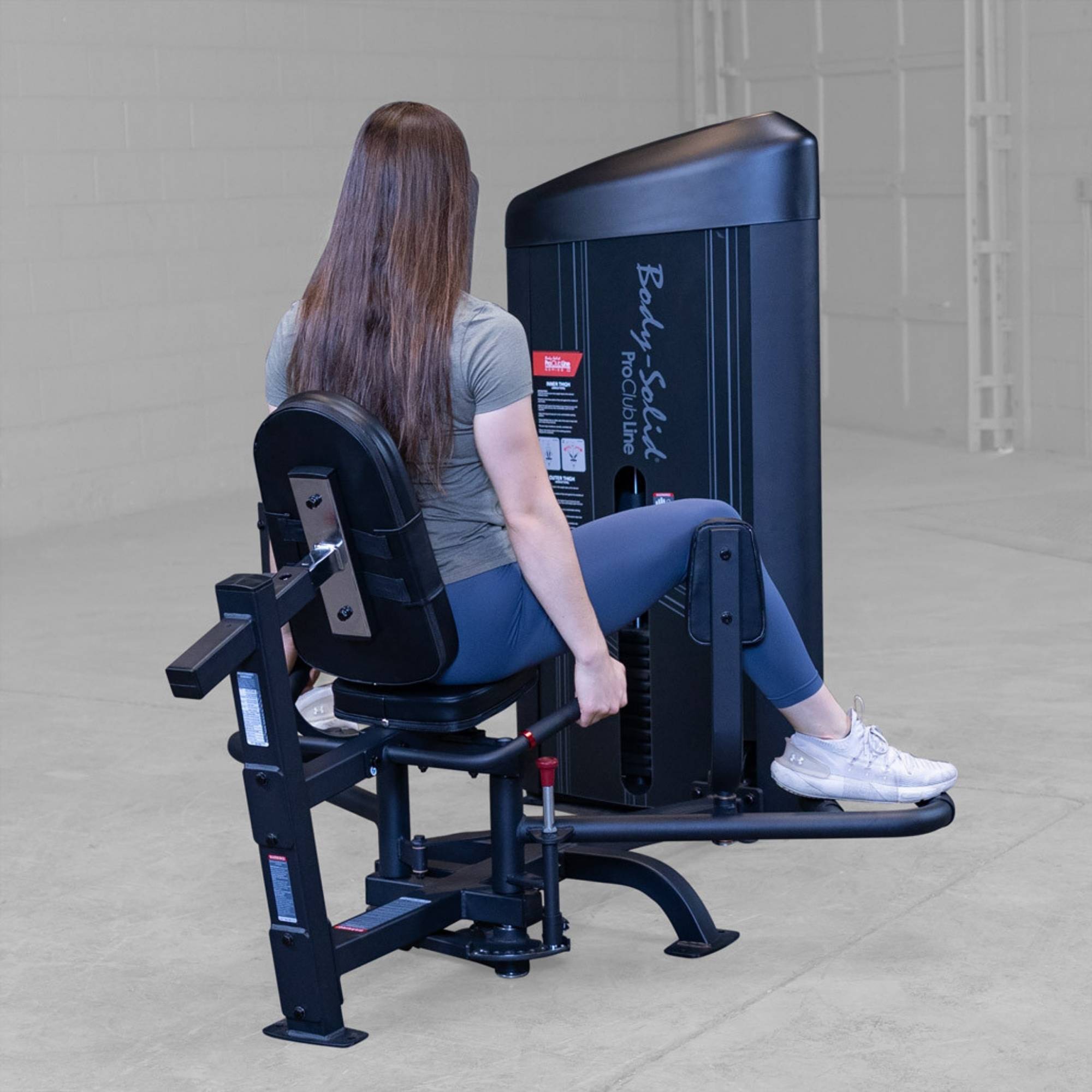 Body-Solid Pro ClubLine Series 2 Inner Outer Thigh S2IOTX Back view of woman seated on a hip abductor machine with legs spread apart during the exercise motion
