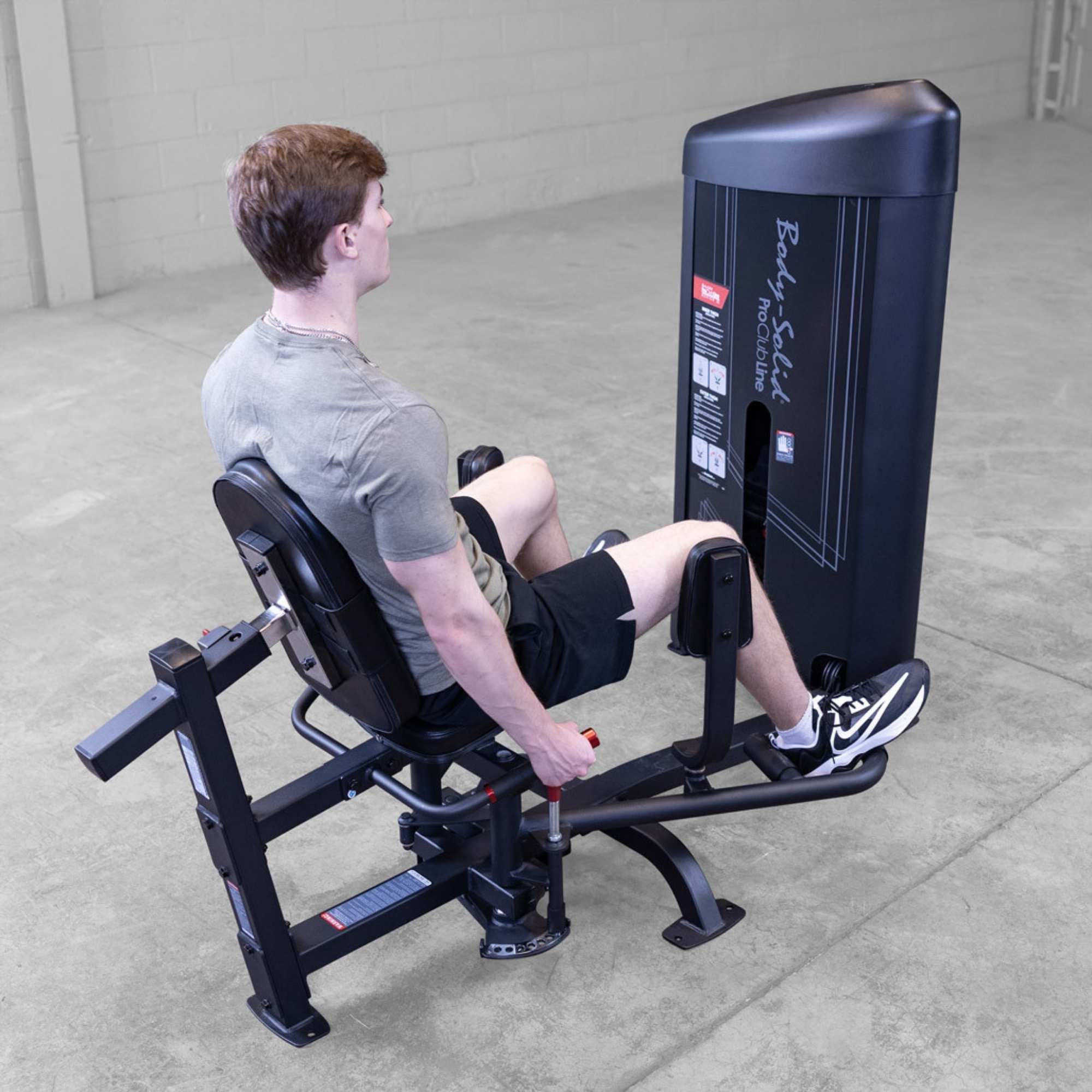 Body-Solid Pro ClubLine Series 2 Inner Outer Thigh S2IOTX Man exercising on hip abduction machine with legs pushing apart, seated upright with hands on handles