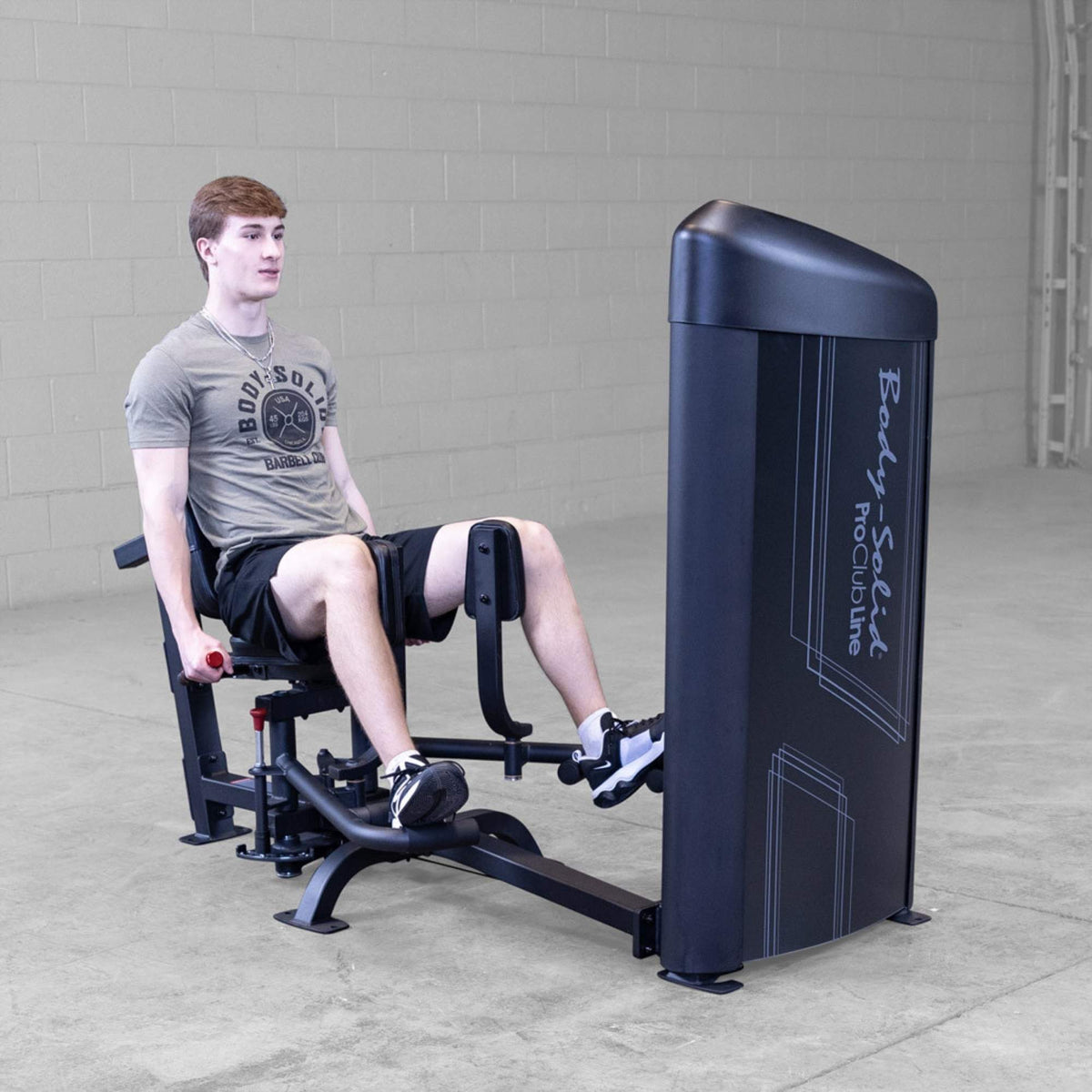 Body-Solid Pro ClubLine Series 2 Inner Outer Thigh S2IOTX Man seated on a Body-Solid hip abductor machine with legs pushing outward against padded resistance