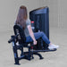 Body-Solid Pro ClubLine Series 2 Inner Outer Thigh S2IOTX Woman seated on hip abduction machine with back toward camera, gripping handles and performing outward leg motion