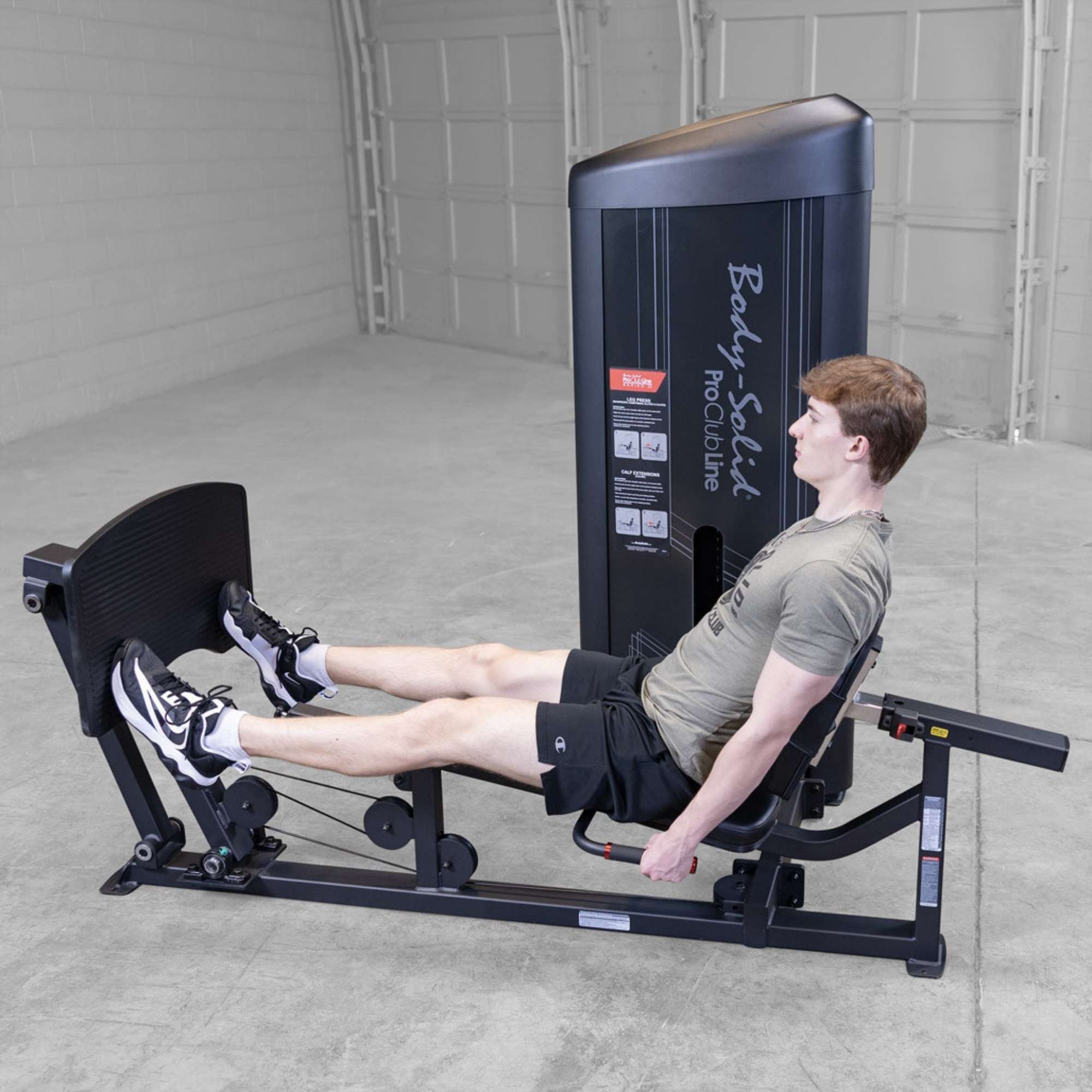 Body-Solid Pro ClubLine Series 2 Leg Calf Press S2LPCX Man extending legs fully on a Body-Solid ProClubLine leg press machine, targeting quadriceps and glutes