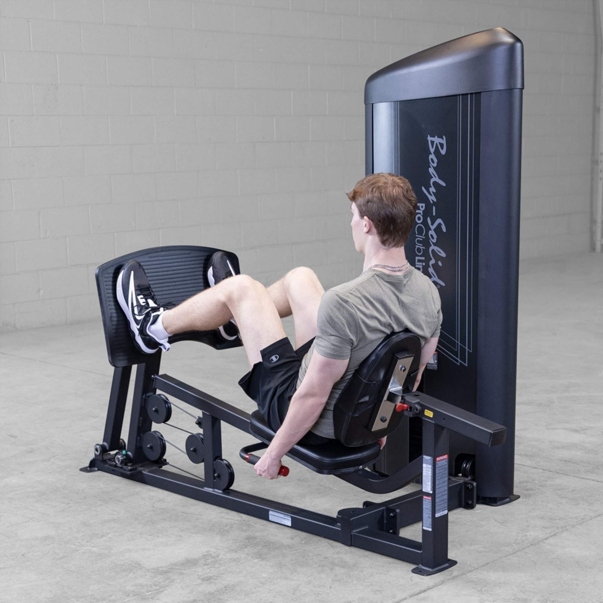 Body-Solid Pro ClubLine Series 2 Leg Calf Press S2LPCX Rear view of man using Body-Solid ProClubLine leg press machine, pushing against footplate to engage leg muscles
