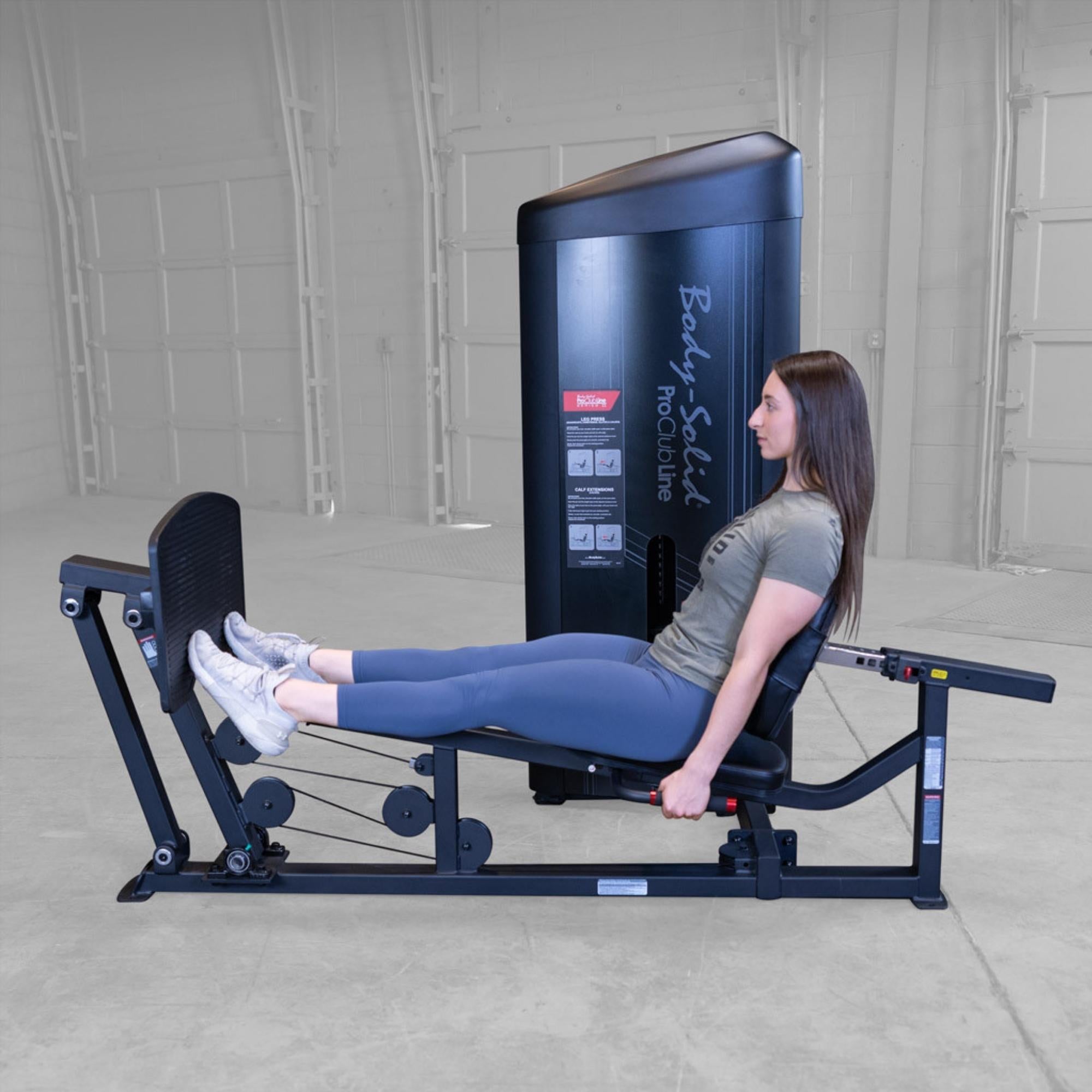 Body-Solid Pro ClubLine Series 2 Leg Calf Press S2LPCX Woman pressing foot platform away from body on leg press machine while engaging quads and glutes
