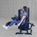 Body-Solid Pro Clubine Series 2 Leg Curl and Extension Leg extension S2LECX exercise in progress with woman raising legs outward against padded rollers on a strength training machine 
