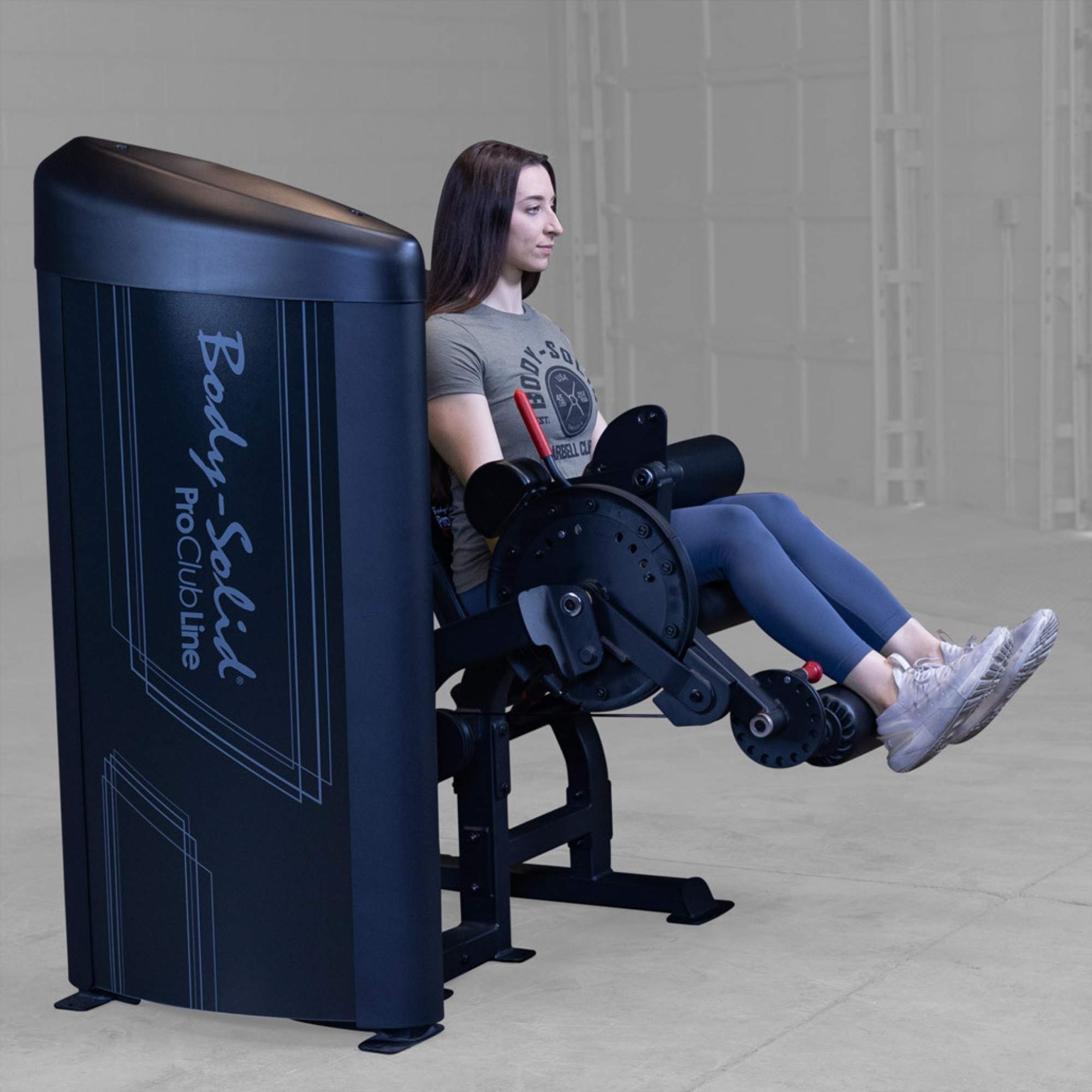 Body-Solid Pro Clubine Series 2 Leg Curl and Extension  S2LECX Full side view of leg extension exercise on Body-Solid ProClubLine equipment, woman lifting legs to straighten knees
