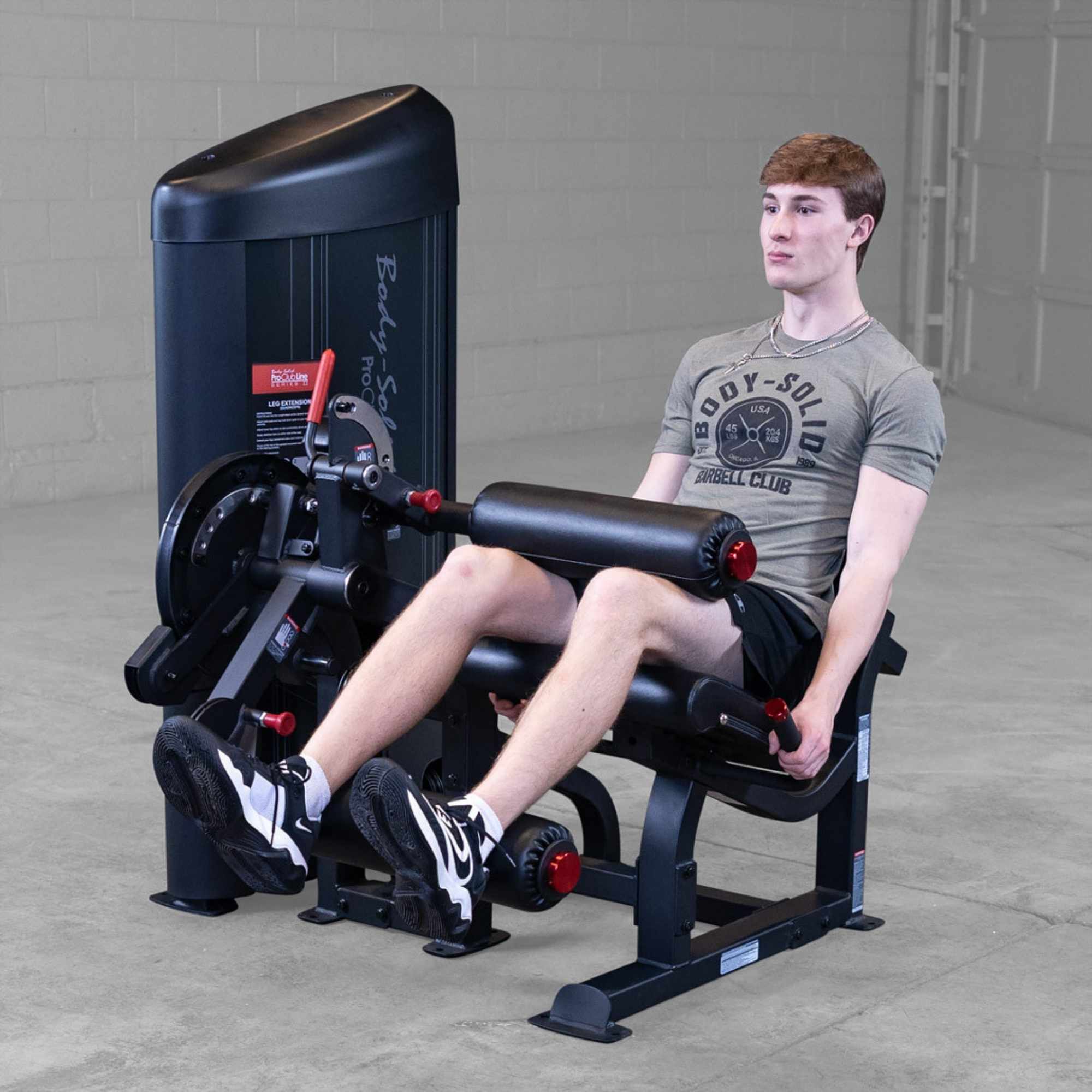 Body-Solid Pro Clubine Series 2 Leg Curl and Extension S2LECX Young man Performing the upward phase of the leg extension exercise in a gym setting 