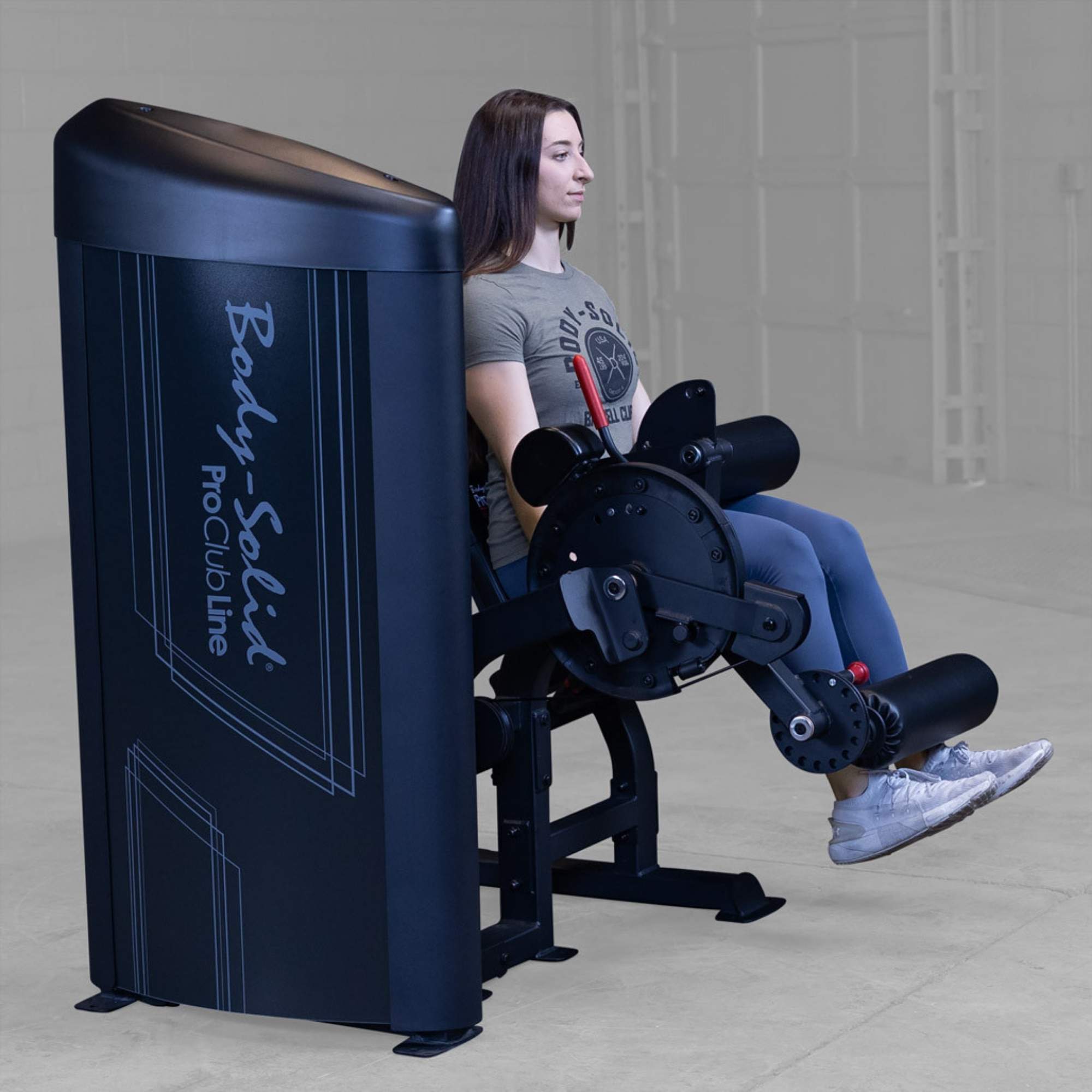 Body-Solid Pro Clubine Series 2 Leg Curl and Extension S2LECX  Side-rear angle of a woman working out on a leg extension machine, pushing weight through padded ankle support 