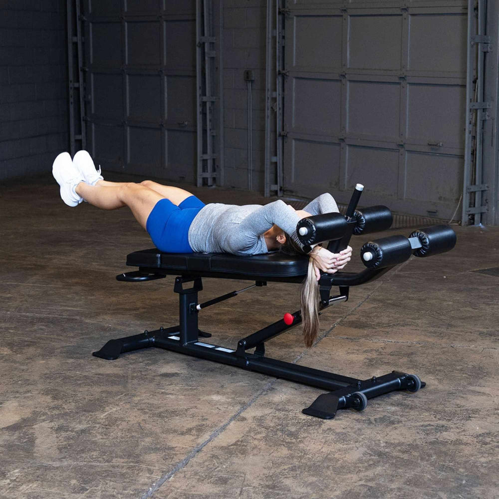 Body-Solid Proclub Commercial Ab Bench SAB500B Woman lying flat on bench performing leg raises