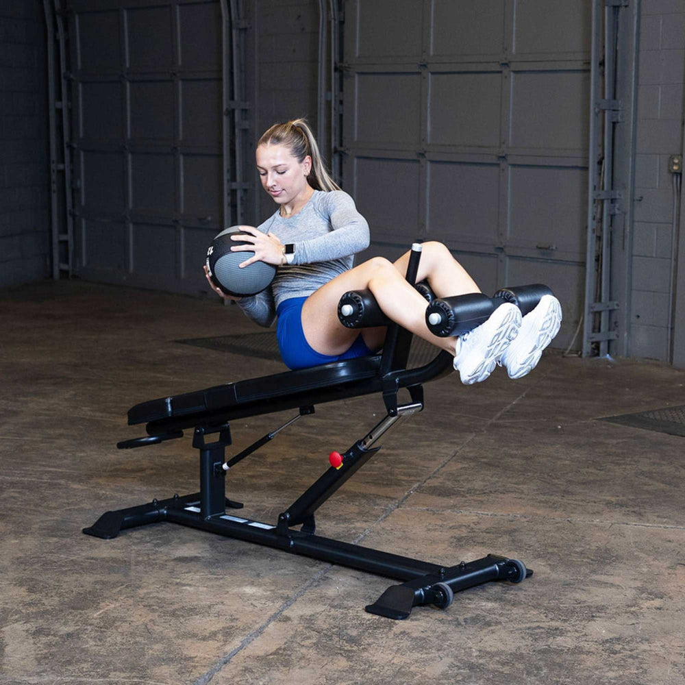 Body-Solid Proclub Commercial Ab Bench SAB500B Woman using a medicine ball while exercising on a sit-up bench