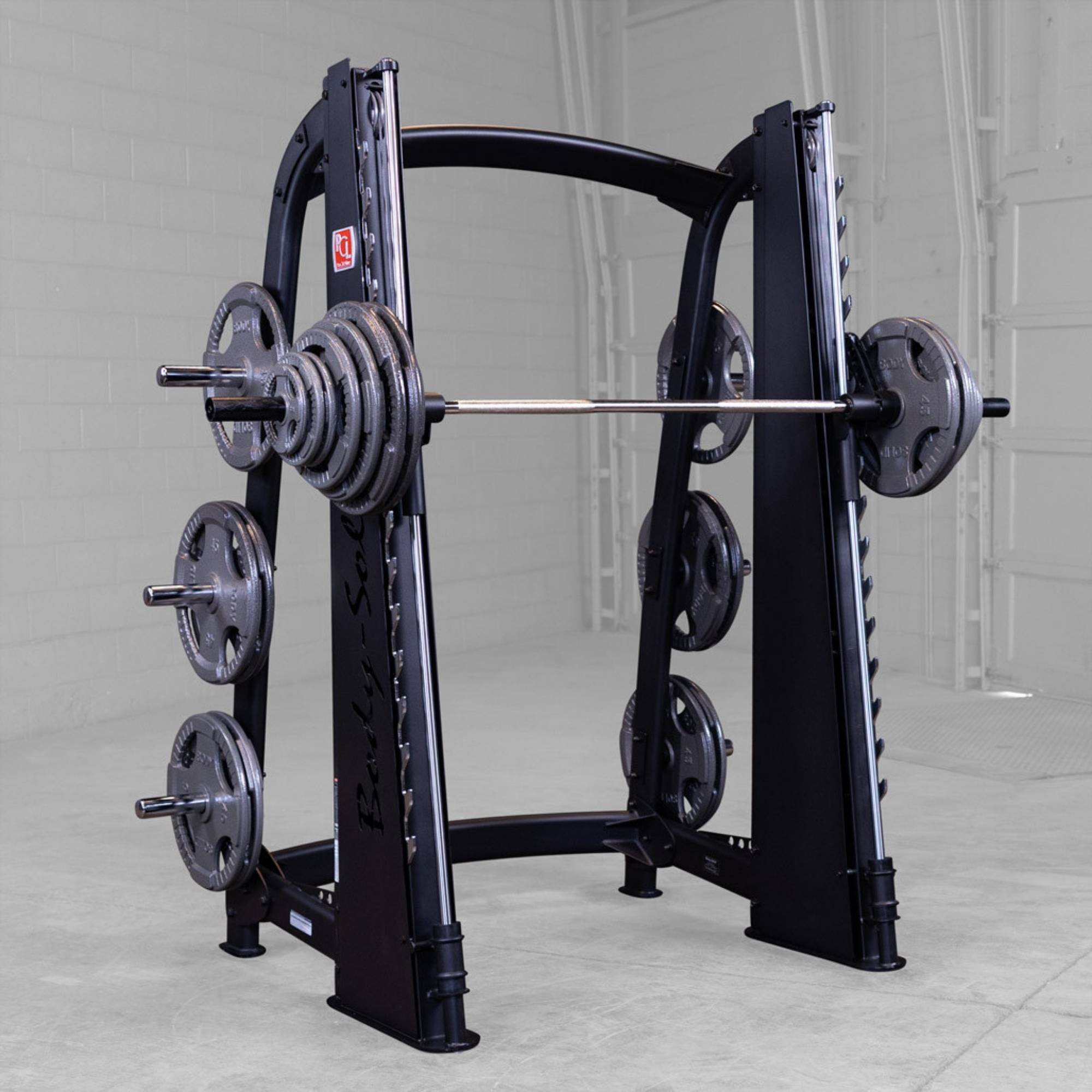 Body-Solid Proclub Counter Balanced Smith Machine SCB1000B Body-Solid Smith machine fully loaded with weight plates on both sides in a commercial gym