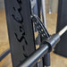 Body-Solid Proclub Counter Balanced Smith Machine SCB1000B Detailed view of the Smith machine barbell safety hook and guide rail mechanism.

