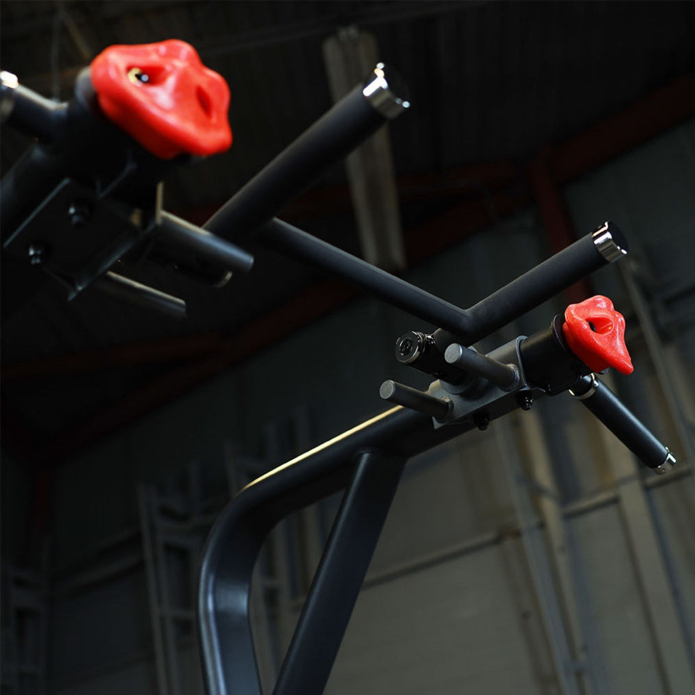 Body-Solid Proclub Vertical Knee Raise SVKR1000BX Close-up angled view of the top pull-up handles on a black power tower, featuring bright red ergonomic grip attachments.